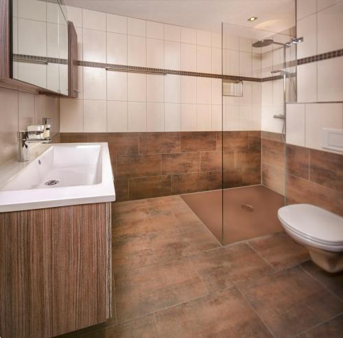 ein Bad mit einem Waschbecken, einem WC und einer Dusche in der Unterkunft Bergmomente Montafon Appartement St. Gallenkirch in Sankt Gallenkirch