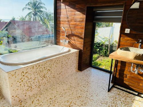 a bath tub in a bathroom with a window at Lotus Home in Phu Quoc