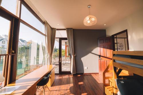 a room with a desk and a large window at Bliss House- Golfvalley Đà Lạt in Da Lat