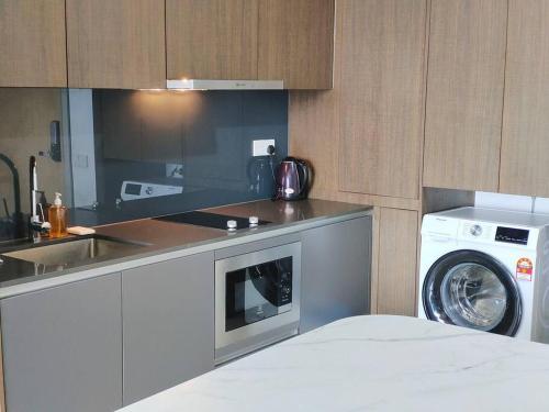 a kitchen with a washing machine and a washer at A2105 Grand Medini Princess100mbps Netflix By STAY in Nusajaya