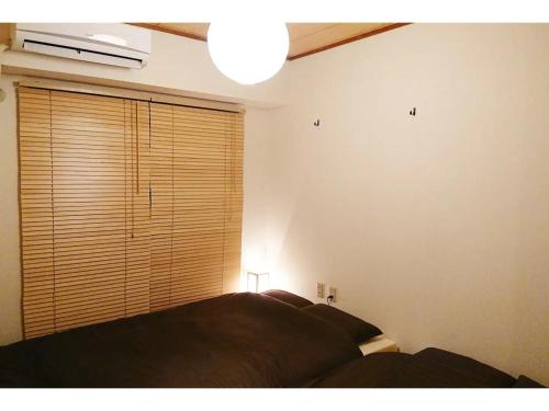 a bedroom with a bed and a large window at SU House Yokohama 305 - Vacation STAY 13162 in Yokohama
