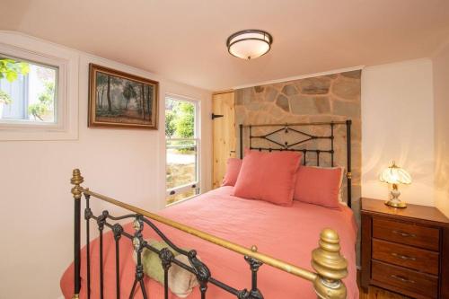 a bedroom with a large bed with red pillows at Delphi, Adelaide Hills Garden BnB in Mylor