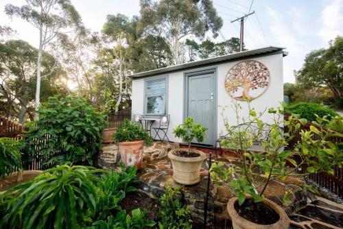 a tiny house in a garden with plants at Delphi, Adelaide Hills Garden BnB in Mylor