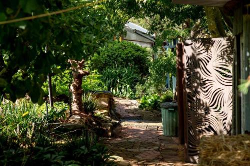 a garden with a zebra print gate and a walkway at Delphi, Adelaide Hills Garden BnB in Mylor
