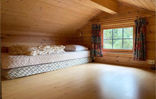 a bed in a log cabin with a window at Stunning Home In Lauvstad With Wifi And 2 Bedrooms in Lauvstad