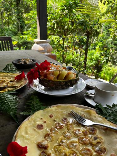 a table topped with plates of food and a pie at Happy Ria Homestay & Guesthouse in Bukit Lawang