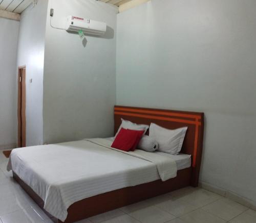 um quarto com uma cama com almofadas vermelhas e brancas em A & A Residence Syariah em Sukarami