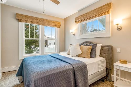 Un dormitorio con una cama y dos ventanas. en The Blue Cottage, en Minocqua