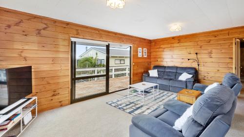 a living room with a couch and a fireplace at Crystal Clear - Snells Beach Holiday Home in Snells Beach