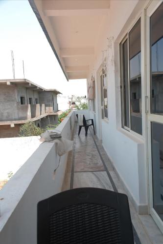a black chair sitting on the porch of a house at Karma Hostel in Khajurāho