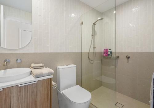 a bathroom with a shower and a toilet and a sink at Sunny Gold Coast Miami Getaway in Gold Coast