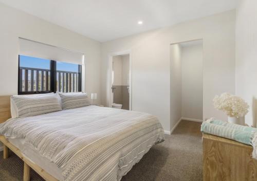 a white bedroom with a large bed and a window at Sunny Gold Coast Miami Getaway in Gold Coast