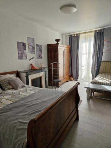 - une chambre avec un grand lit et une cheminée dans l'établissement Appartement 120 m² duplex cœur historique au calme, au Puy-en-Velay