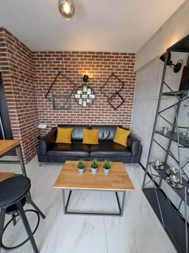 a living room with a couch and a brick wall at Seaside Dream in Thessaloniki