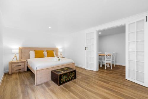 um quarto branco com uma cama e uma mesa em Villa Marina by the Sea - Pet Friendly em Kingscliff