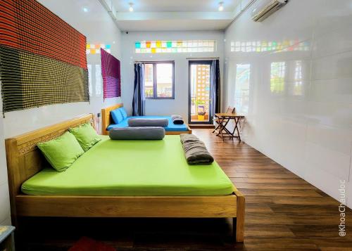 Habitación con cama verde en una habitación en Homestay Khoa Chaudoc, en Chau Doc
