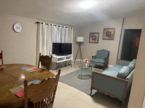 a living room with a table and a couch and a television at Oak Ridge House in Tampa