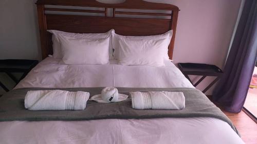 a stuffed bird sitting on a bed with two pillows at Langstrand Beach House in Langstrand