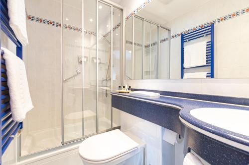 a bathroom with a shower and a toilet and a sink at Hotel Re'ser Stuff in Roeser