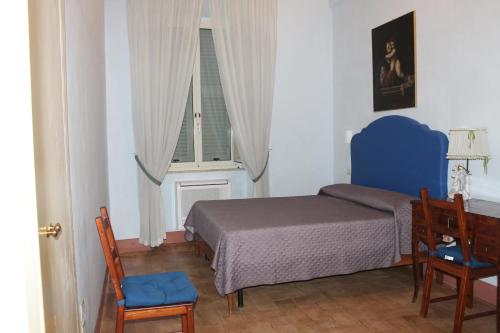 a bedroom with a bed and two chairs and a window at Palazzo Trevisani in Porto San Giorgio
