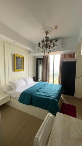 a bedroom with a large bed with a blue blanket at Alexa Meisterstadt pollux habibie in Batam Center