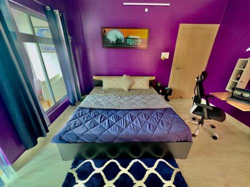 a purple bedroom with a bed and a desk at Three Little Birds Homestay in Guwahati