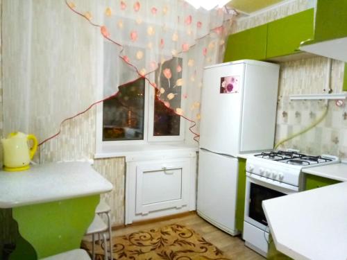 cocina con nevera blanca y fogones en 3-х комнатная квартира район ЖД вокзала, en Kostanái