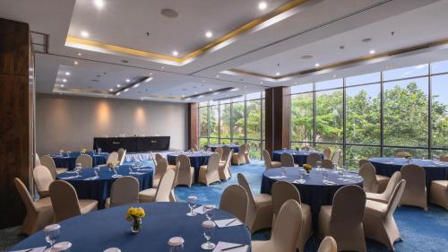 a conference room with blue tables and chairs and windows at Veranda Hotel Pakubuwono in Jakarta