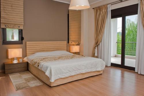 a bedroom with a bed and a large window at Villa Maltina in Kassandrinón