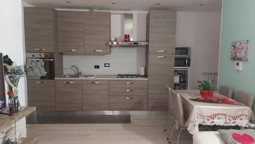 a kitchen with wooden cabinets and a table in it at Appartamento Amy in Perugia