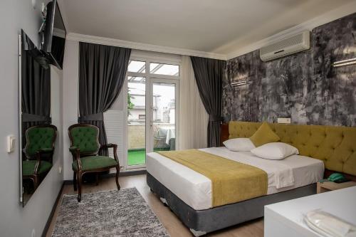 Un dormitorio con una cama y una silla y una ventana. en Hotel Pera Capitol, en Estambul