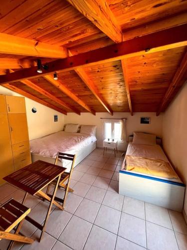 een kamer met twee bedden en een tafel erin bij Καλοκαιρινό σπίτι δίπλα στη θάλασσα in Gialiskari