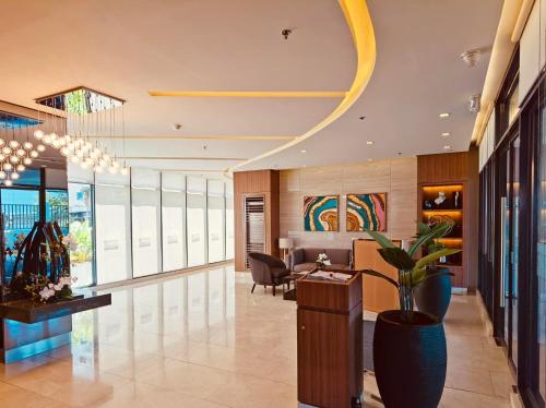 an office lobby with a potted plant in the middle at Condominium at Spring Residences near Airport in Manila