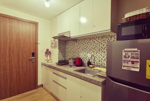 a small kitchen with a sink and a refrigerator at Condominium at Spring Residences near Airport in Manila