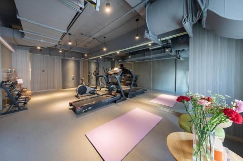 a room with a gym with a treadmill and flowers at Atour Hotel Hefei Changjiang Road in Hefei