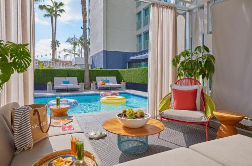 a patio with a pool with chairs and a table at Viceroy Santa Monica in Los Angeles