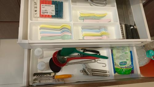 a refrigerator with a drawer full of kitchen utensils at Cozy Southville Bangi Free parking Wifi Netflix in Bangi
