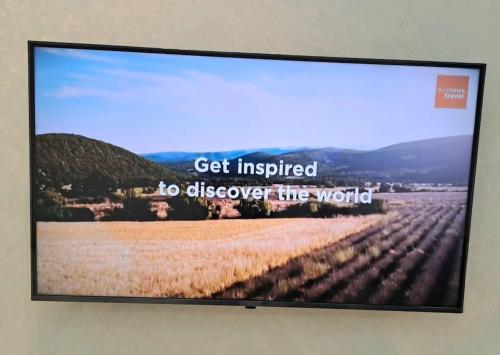 a television screen with a picture of a field at Apartment in City Center in Dushanbe