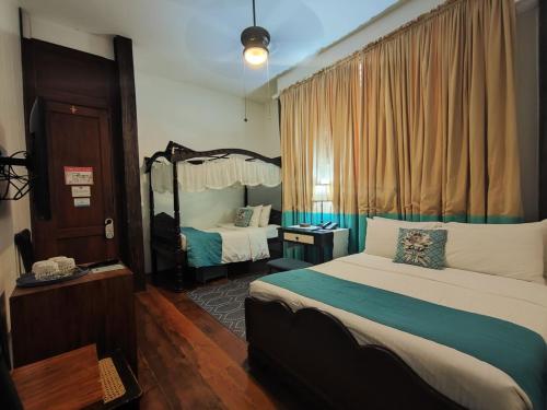 a hotel room with a bed and a mirror at Paradores Del Castillo in Taal