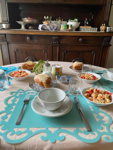 un tavolo con piatti e ciotole di cibo sopra di BASISA Bed&Breakfast a San Lazzaro di Savena