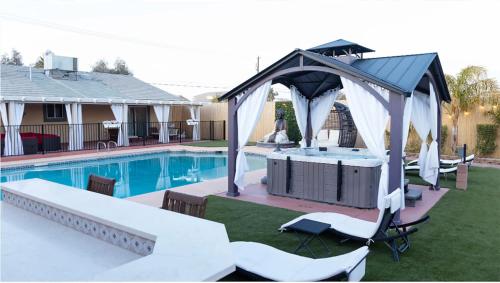 a pool with a gazebo next to a swimming pool at Buddha Mansion Luxury Resort - 8BR Modern, HotTub, Huge pool, Sauna, BBQ grill, Game Room in Las Vegas