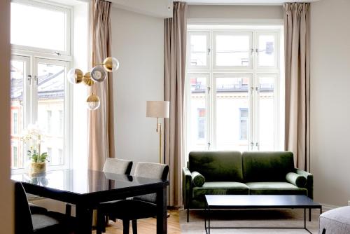 uma sala de estar com um sofá verde e uma mesa em Frogner House - Bislett em Oslo