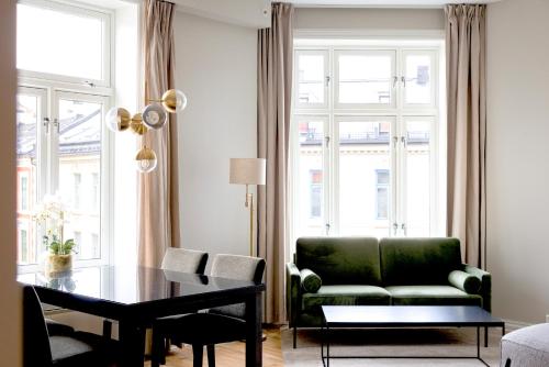 a living room with a green couch and a table at Frogner House - Bislett in Oslo