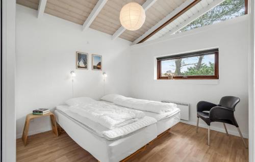 una camera bianca con un letto e una sedia nera di Awesome Home In Fan With Wifi a Fanø