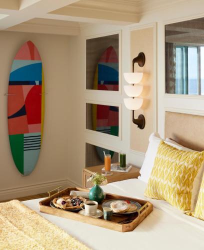 a tray of food on a bed in a room at Viceroy Santa Monica in Los Angeles