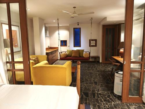 a living room with a yellow chair and a couch at The Sky Imperial Aarivaa Luxury Stays in Rajkot