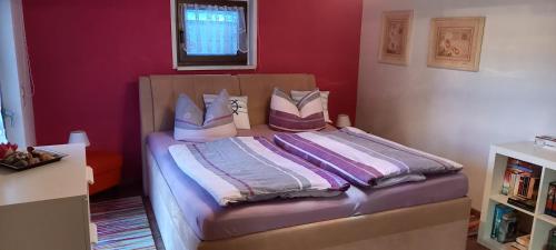 ein Schlafzimmer mit einem Bett mit lila Wänden in der Unterkunft Rosenparadies in Kröpelin
