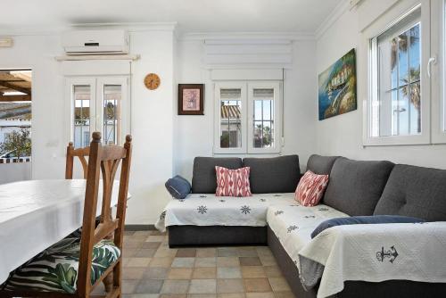 Casa Vistas al Mar Bolonia في تريفة: غرفة معيشة مع أريكة وطاولة