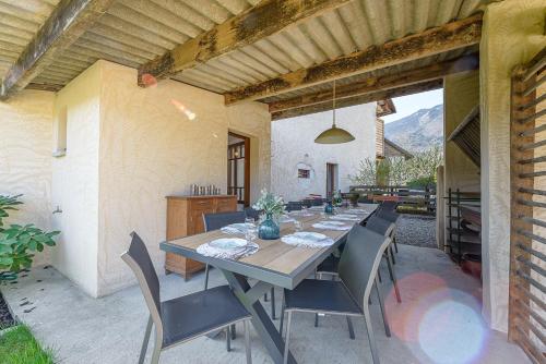 Une table à manger et des chaises sont disponibles sur la terrasse. dans l'établissement ST JORIOZ- Le Nid O Grives, maison familiale entre lac et montagnes- Home cinema- LLA Selections by Location lac Annecy, à Saint-Jorioz