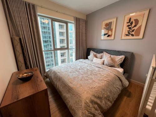 een slaapkamer met een bed en een groot raam bij BLVBD Central Full Burj View 1402 in Dubai